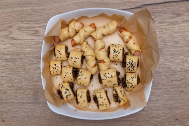 Taze yapılmış, mantarlı hamur köftesi, yağla kaplanmış, pişirme tepsisinde yatıyor..