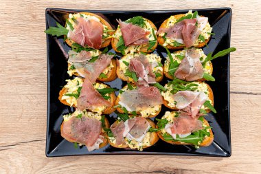 Siyah tabakta servis edilen atıştırmalıklar yenmeye hazır.