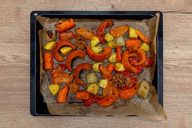 Fırın tepsisi üzerinde fırınlanmış sebze ve parşömen kağıdı karışımı.