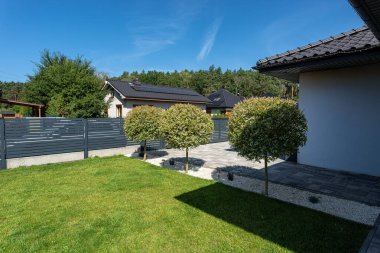 Güneşli bir günde çağdaş bir konutun bahçesini düzenledim.