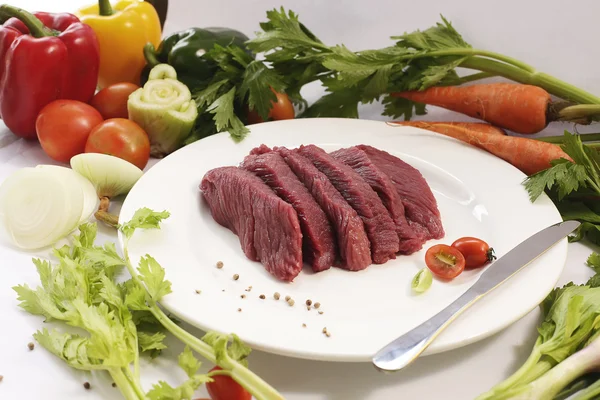 Tranche de viande d'autruche crue avec des légumes — Photo