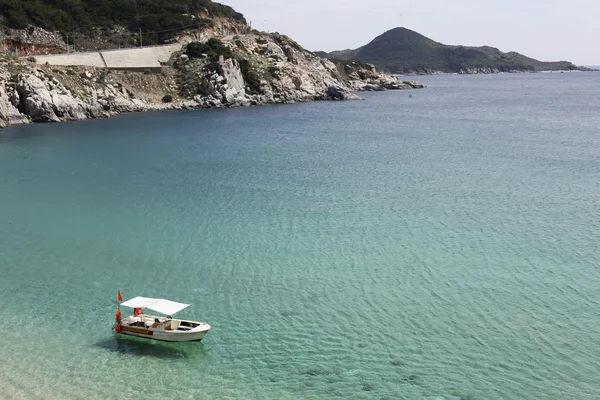 Mavi gökyüzü ve dağ, kayalık sahil ile plajda kayalar