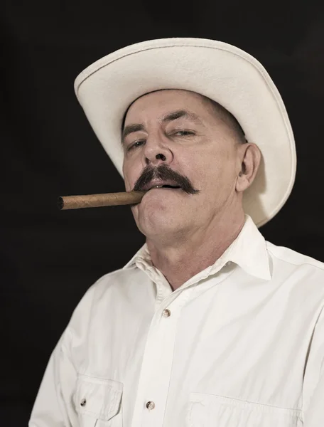 Kowboj z wąsem w białym kapeluszu, palący cygaro — Zdjęcie stockowe