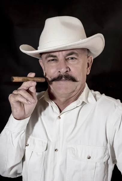 Il cowboy con baffi in un cappello bianco, fumando un sigaro — Foto Stock