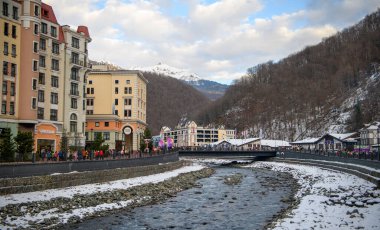 Soçi; Rusya - 02 Ocak 2021: Krasnaya Polyana tatil köyündeki Mzymta nehri. Turistler set boyunca yürür