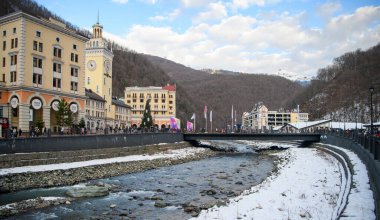 Soçi; Rusya - 02 Ocak 2021: Krasnaya Polyana tatil köyündeki Mzymta nehri. Turistler set boyunca yürür