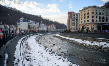 Soçi; Rusya - 02 Ocak 2021: Krasnaya Polyana tatil köyündeki Mzymta nehri. Turistler set boyunca yürür