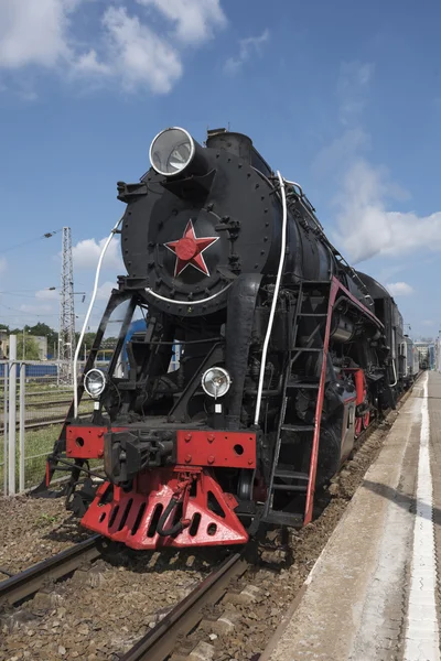 A locomotiva do século passado de pé sob vapor — Fotografia de Stock