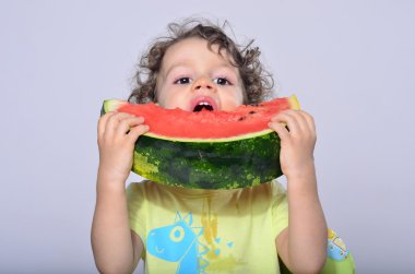 Bir dilim tatlı lezzetli karpuz yeme yürümeye başlayan çocuk. Kavun bir parçası bitting ve dağınık Başlarken aç çocuk