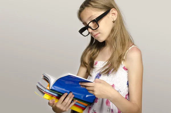 Menina com óculos lendo alguns livros, criança aprendendo, criança estudando — Fotografia de Stock