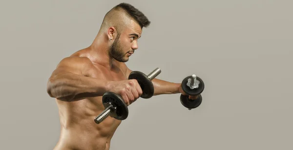 Homme de bodybuilder fort avec abdos, épaules, biceps, triceps et poitrine parfaits, entraînement de fitness personnel avec haltères lourds — Photo