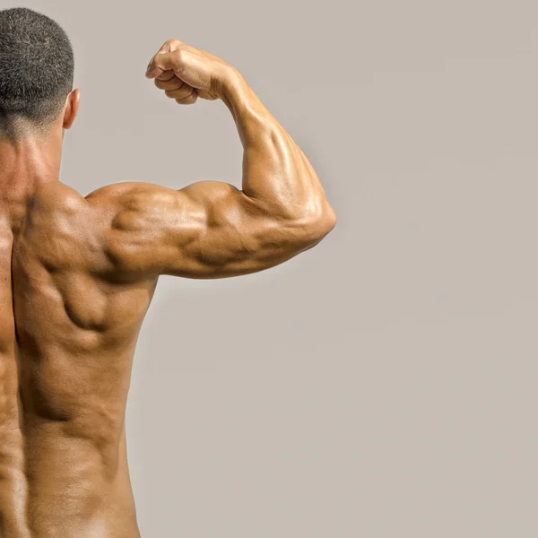 Fisiculturista mostrando suas costas e músculos bíceps isolados em um fundo branco, personal fitness trainer — Fotografia de Stock