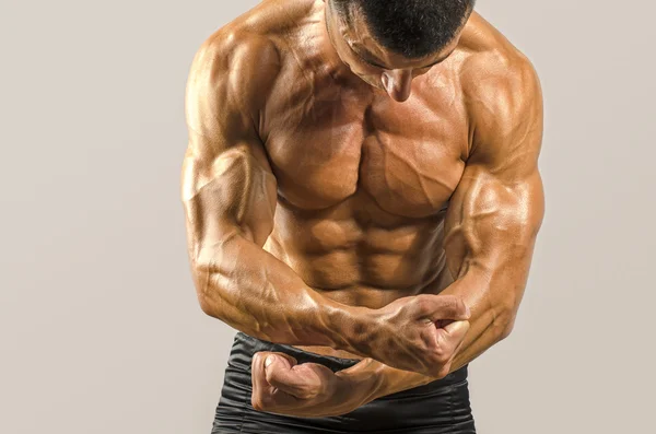 Güçlü bir vücut geliştirmeci adam mükemmel abs, omuzlar, pazı, triceps ve göğüs, kişisel fitness eğitmeni ile — Stok fotoğraf