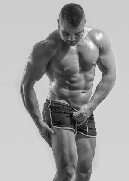 Culturista fuerte con abdominales perfectos, hombros, bíceps, tríceps y pecho, entrenador de fitness personal, flexionando sus músculos —  Fotos de Stock
