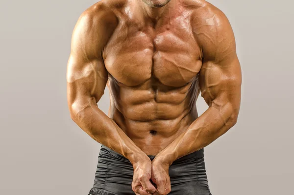 Stark kroppsbyggare med perfekta abs, axlar, biceps, triceps och bröst, personlig tränare, muskelbygge hans muskler — Stockfoto