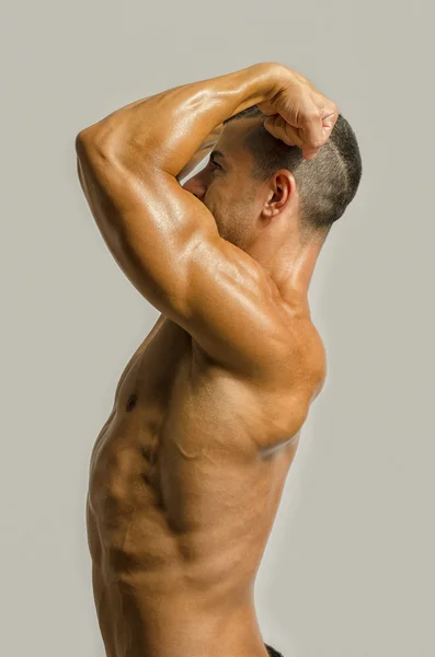Kehonrakentaja osoittaa hänen selkänsä, hartiat, triceps ja hauis lihakset, henkilökohtainen kunto kouluttaja — kuvapankkivalokuva