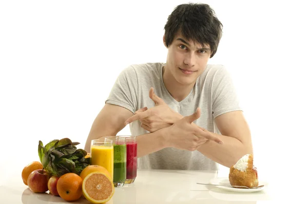 Man choosing between fruits, smoothie and organic healthy food against sweets, sugar, lots of candies — Stock Photo, Image