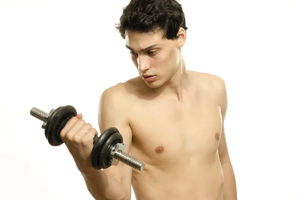 Hombre flaco entrenando su músculo bíceps. Hermosa adolescente levantando una dumbbell.Anorexic joven entrenamiento para ser más fuerte —  Fotos de Stock