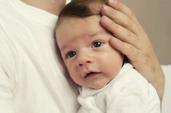 Mãos do pai segurando seu recém-nascido com amor, protegendo-o, bebê inocente sentindo-se seguro no peito de seu pai — Fotografia de Stock