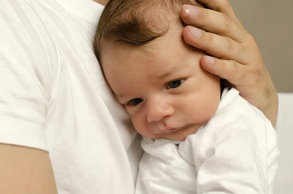 Mãos do pai segurando seu recém-nascido com amor, protegendo-o, bebê inocente sentindo-se seguro no peito de seu pai — Fotografia de Stock