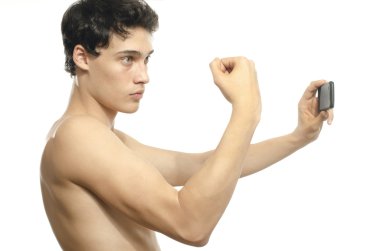 Telefonunu onun pazı kas ile bir selfie alarak sıska adam. Bir vücut geliştirmeci poz ve onun facebook için fotoğraf çekme anoreksik adam