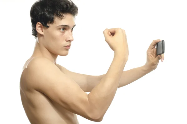 Magere man nemen een selfie met zijn telefoon van zijn biceps spier. Anorexia man die zich voordeed als een bodybuilder en het nemen van een foto voor zijn facebook — Stockfoto