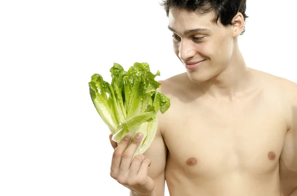 Ein hagerer junger Mann isst einen gesunden Bio-Salat und ernährt sich. Grünes Essen für ein gesundes Leben und eine perfekte Ernährung — Stockfoto