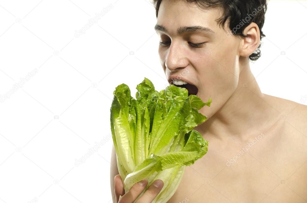 Skinny young man eating an organic healthy salad and dieting. Green food for a healthy life and a perfect diet
