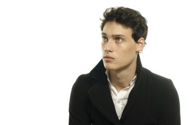 Güzel genç bir adam portresi moda poz bir siyah uzun ceket içinde giyinmiş