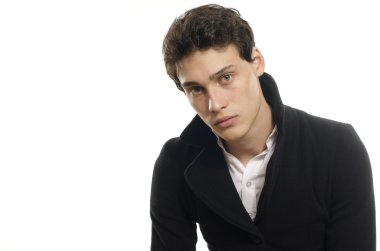 Güzel genç bir adam portresi moda poz bir siyah uzun ceket içinde giyinmiş