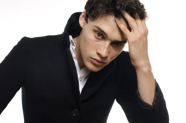 Portrait of a beautiful young man dressed in a black long coat, upset and stressed — Stock Photo, Image