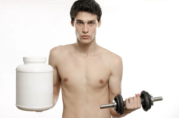 Hombre flaco entrenando su músculo bíceps y tomando un batido de proteínas. Hermosa adolescente levantando una dumbbell.Anorexic joven entrenamiento para ser más fuerte y el uso de esteroides — Foto de Stock