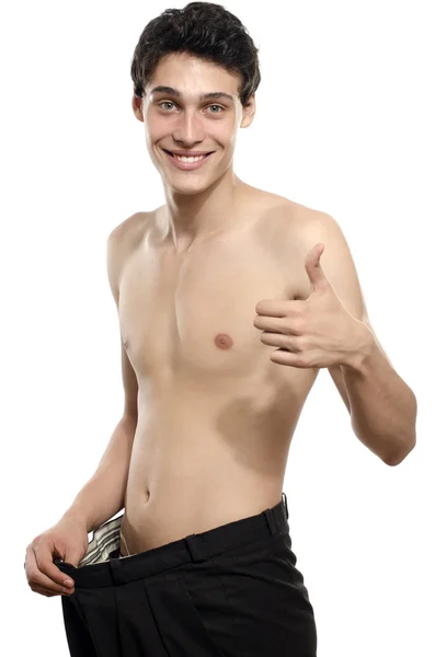 Skinny ung man med stora byxor, anorektisk look, smal kropp. Mannen gick ner i vikt och jämförde sina större byxor från den tiden han var fet. Före och efter, fett eller smal — Stockfoto