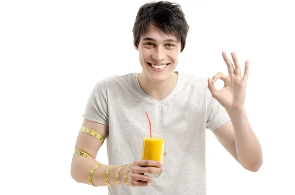 Man measuring his biceps with a centimeter while drinking organic healthy smoothie for a perfect diet. Green food for a healthy life — Stock Photo, Image