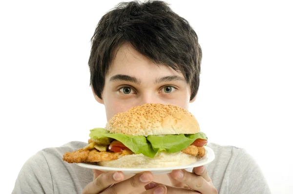 Uomo che offre un grande hamburger, fast food, portare fuori per voi — Foto Stock