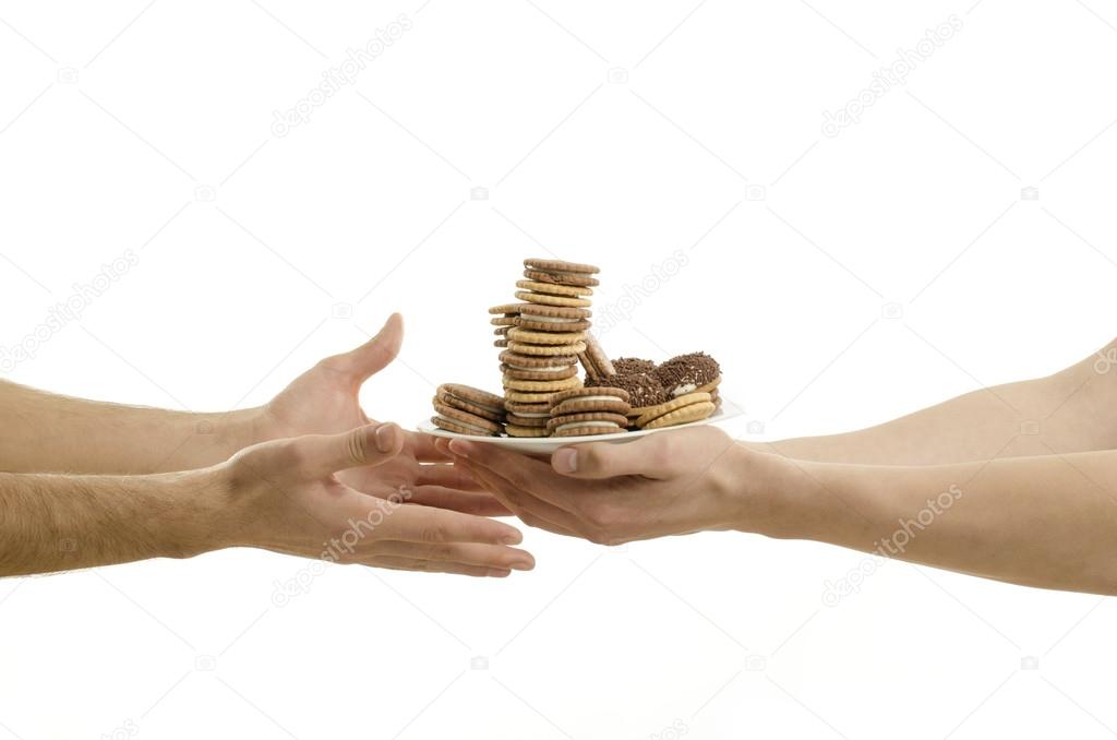 Man's hand offering chocolate, cupcakes, biscuits, cookies, muffins and oher hands receiving. Lots of sugar in a plate
