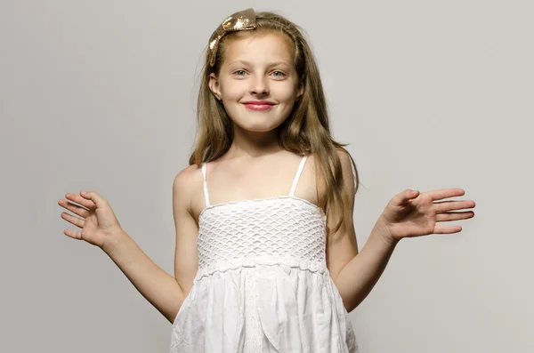 Hermosa joven rubia en vestido blanco sonriendo y jugando. Niño disfrutando de la vida y divertirse —  Fotos de Stock