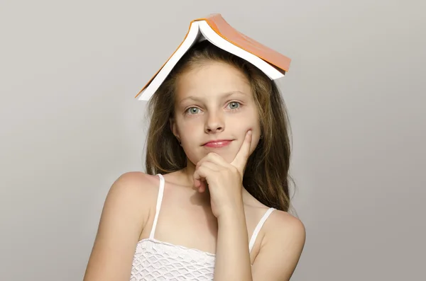 Menina lendo alguns livros, criança aprendendo, criança estudando, criança se divertindo com um livro — Fotografia de Stock