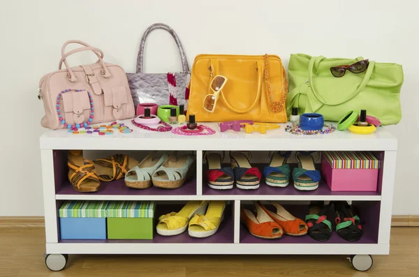 Lots of colorful summer accessories on a shelf. Bags, jewelry, shoes and sandals nicely arranged on a shelf — Stock Photo, Image