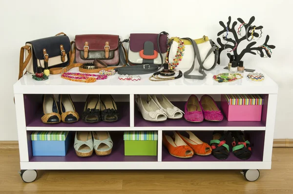 Beaucoup d'accessoires d'été colorés sur une étagère. Sacs, bijoux, chaussures et sandales joliment disposés sur une étagère — Photo