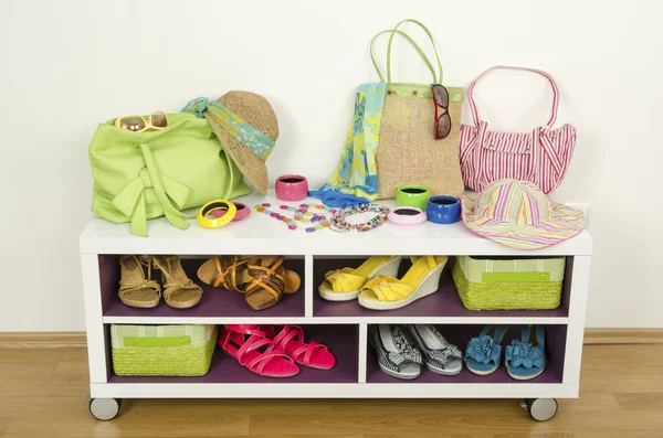 Allerlei kleurrijke zomer accessoires op een plank. Tassen, sieraden, schoenen en sandalen mooi gerangschikt op een plank — Stockfoto