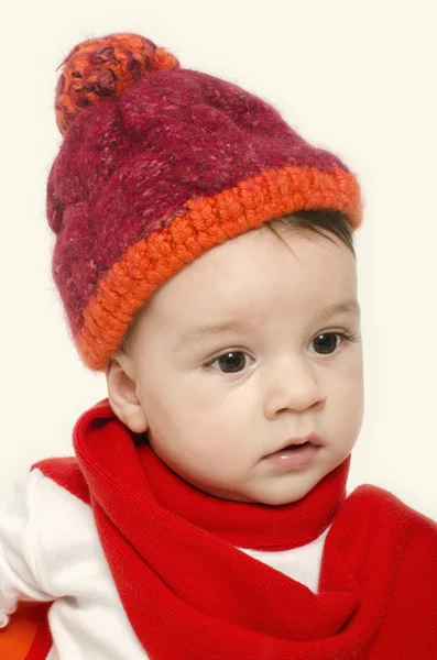 Bambino innocente che indossa un cappello rosso e una marmitta e sembra adorabile. Bambino piccolo vestito per l'inverno — Foto Stock