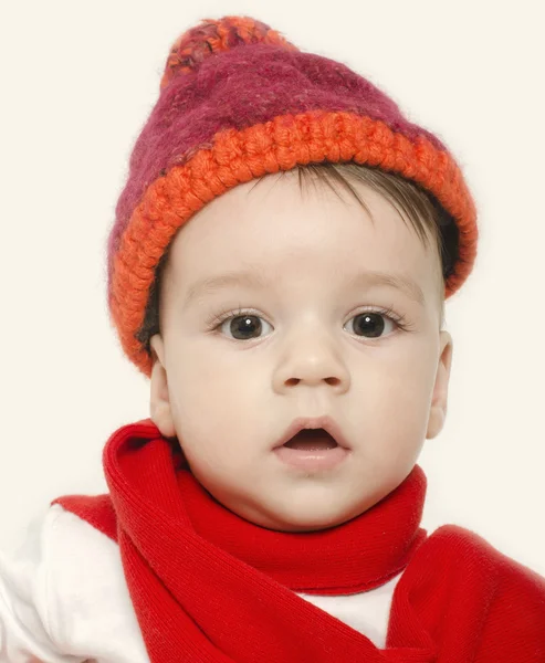Niewinne dziecko ubrany w czerwony kapelusz i szalik i wygląd adorable. Małe dziecko ubrane na zimę — Zdjęcie stockowe