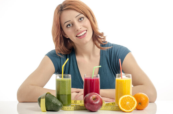 Happy woman having a table full of organic food,juices and smoothie. Cheerful young woman eating healthy salad and fruits. Isolated on white.