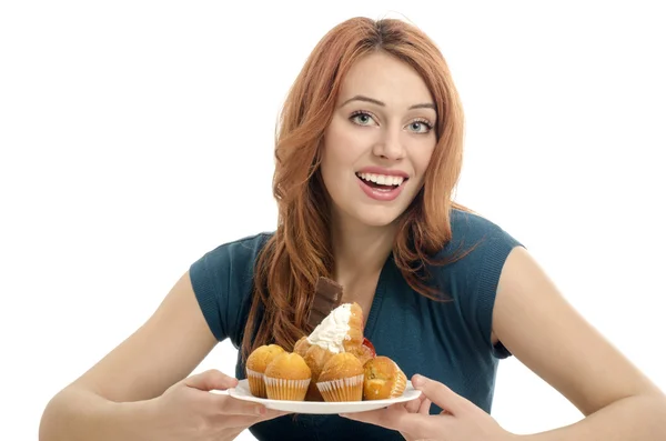 Menina se divertindo e comendo muitos biscoitos, muffins, fondants. Mulher apaixonada por doces, doces, chocolate e açúcar — Fotografia de Stock