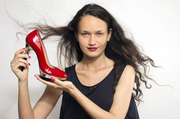 Mulher apaixonada por seus sapatos de salto alto. Menina bonita segurando seu sapato estilete sexy vermelho. Senhora compras de sapatos — Fotografia de Stock