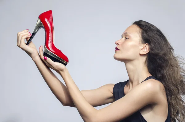 彼女の高いヒールの靴に恋する女。美しい少女は、彼女の赤いセクシーなスチレットヒールの靴を保持しています。女性の靴のための買い物 — ストック写真
