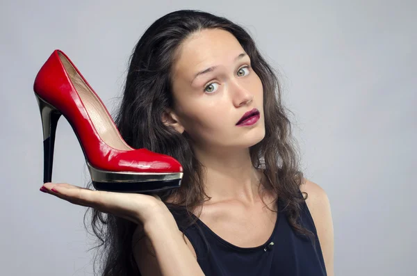 Woman in love with her high heel shoes. Beautiful girl holding her red sexy stiletto shoe. Lady shopping for shoes — Stock Photo, Image