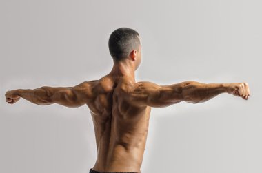 Beyaz bir arka plan üzerinde kişisel fitness eğitmeni izole sırt ve pazı kas gösterilen vücut geliştiricisi. Güçlü adam kasların esneme