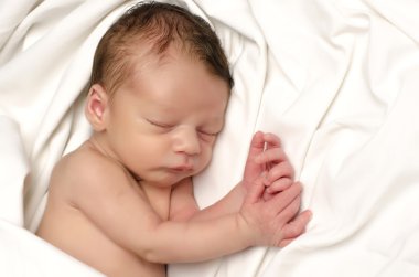 Güzel masum yeni doğan uyuyor. Sevimli küçük çocuk banyo sonra beyaz çarşaflarla rahatlatıcı. Tatlı rüyalar görüyorum bebek